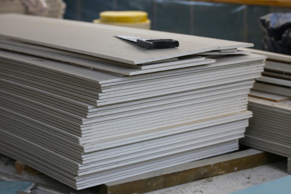 Byggprocessen invändigt – gipsskivor staplade inför väggbeklädnad i ett nybyggt hus.